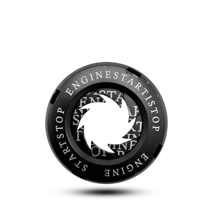 ** Black key ignition cover with "ENGINE START STOP" text around the edge and a central iris design. **